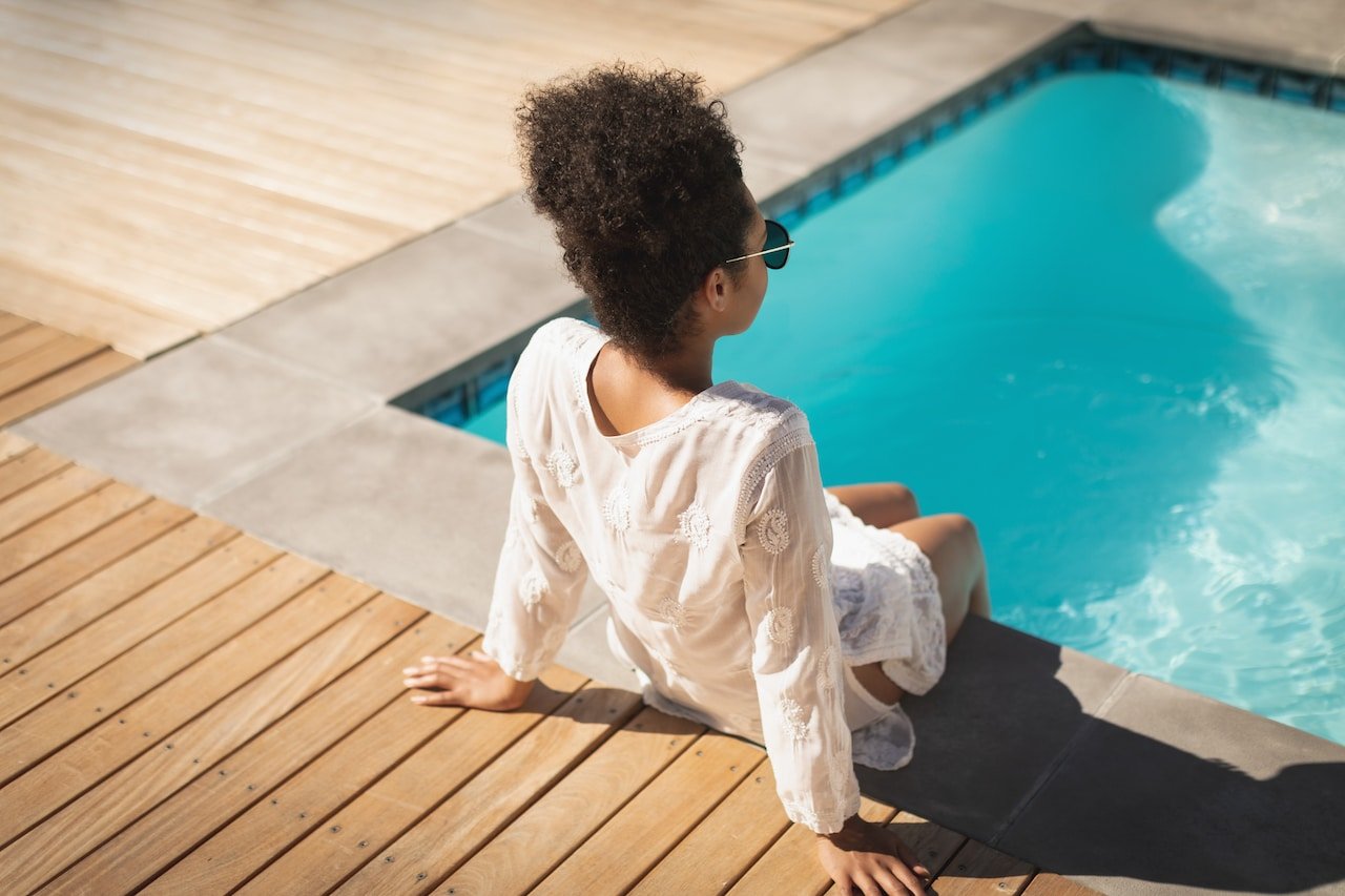 Blog 1 woman sitting beside a small backyard pool