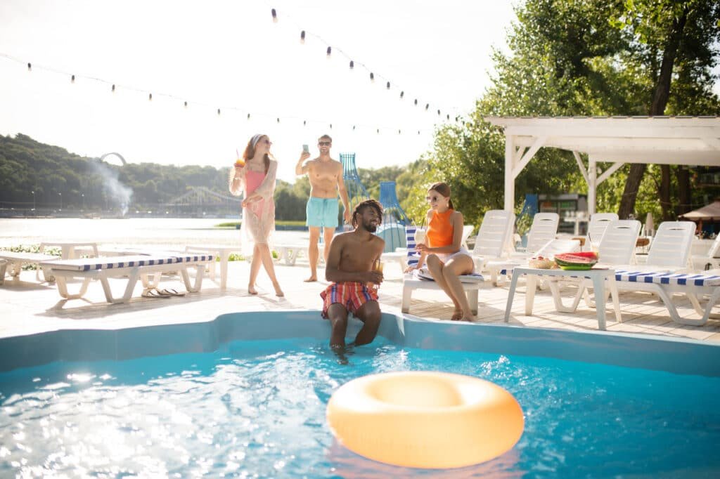 How to Prep Your Pool for Summer: Your Pool Prep Checklist! 7 Two couples having a pool party